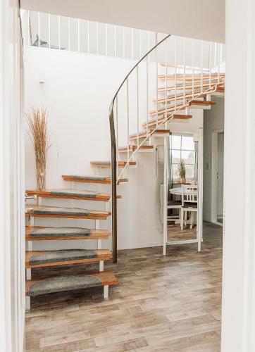 a staircase in a living room with wood floors at Ferienhäuser Insel Usedom Haus Jojo 7 - Blick aufs Achterwasser! Whirlpool und Sauna in Lütow