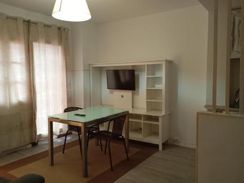 a living room with a table and a tv at La Casona de Betanzos in Betanzos