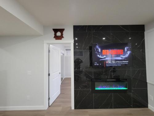 a bathroom with a tv on a wall at Cozy and Modern Suite - Your Home Away from Home! in Calgary