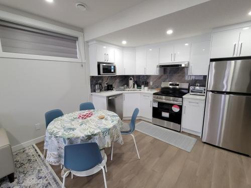 a kitchen with a table and chairs and a refrigerator at Cozy and Modern Suite - Your Home Away from Home! in Calgary