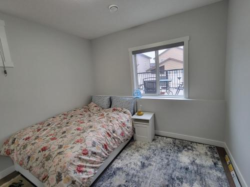 a bedroom with a bed and a window at Cozy and Modern Suite - Your Home Away from Home! in Calgary