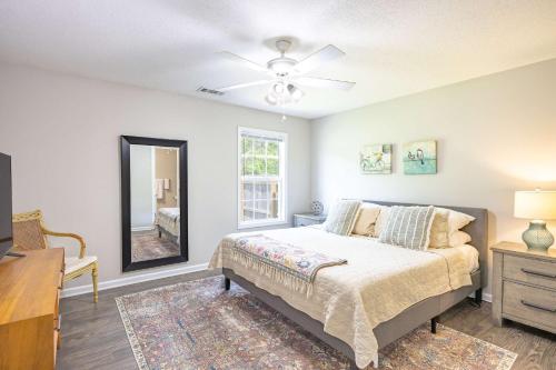 a bedroom with a bed and a dresser and a mirror at Cozy and Contemporary Villa 1 Mile from GSU in Statesboro
