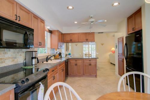 a kitchen with wooden cabinets and a ceiling fan at Glimmering Shells in Sanibel