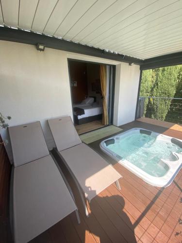a patio with a jacuzzi tub on a deck at L'ESCALE COTE BLEUE B&B AND Spa in Sausset-les-Pins