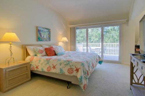 a bedroom with a bed and a large window at Glimmering Shells in Sanibel