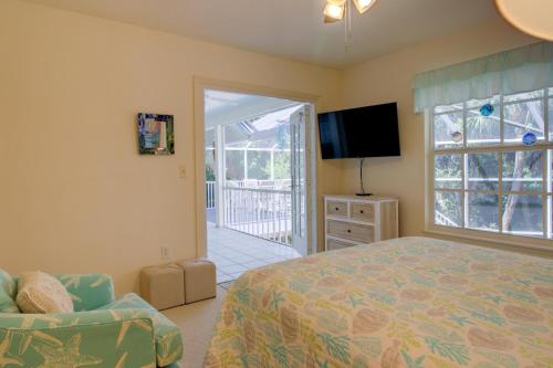 a bedroom with a bed and a chair and a television at Glimmering Shells in Sanibel