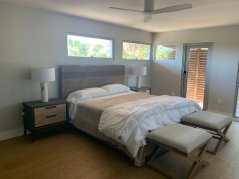 Un dormitorio con una cama grande y dos sillas. en Bentley Beach House, en Sanibel