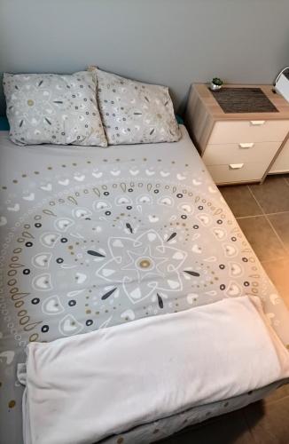 - un lit avec une couette blanche dans l'établissement Chambre salle de bain clim, à Saint-Laurent-de-Mure