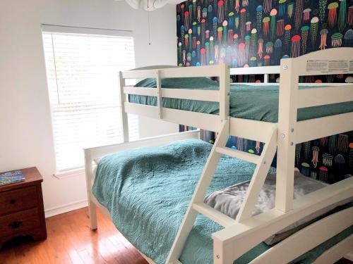 a bedroom with a bunk bed with a ladder at The Beach Peach in Port Aransas