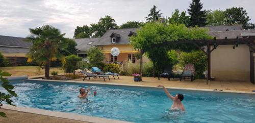 two people are playing in a swimming pool at La Tourelle - Bed and Breakfast et gîte in Changé