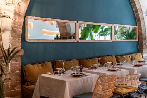 a dining room with white tables and chairs at Le Palazzo in Essaouira