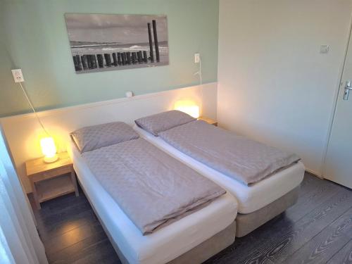 En eller flere senge i et værelse på Appartement vlakbij centrum en strand