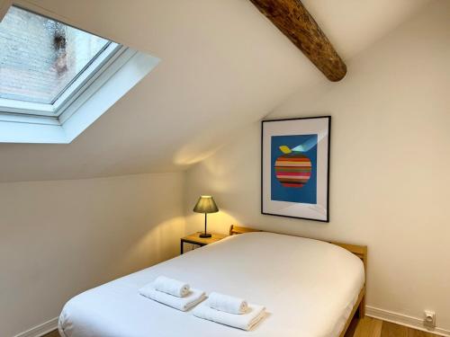 une chambre avec un lit avec deux serviettes dessus dans l'établissement Les Arches de Vesle à Reims, à Reims