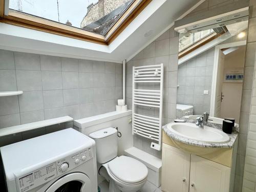 une salle de bain avec une machine à laver et un lavabo dans l'établissement Les Arches de Vesle à Reims, à Reims