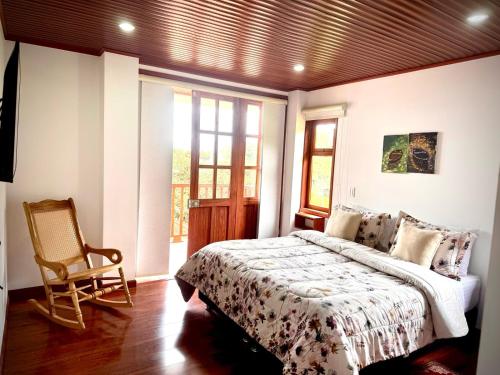a bedroom with a bed and a chair in it at Villa Lulu in Tibasosa