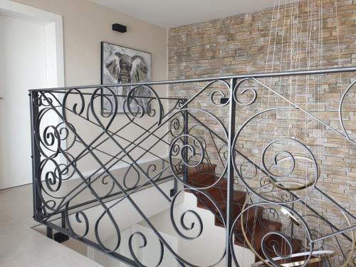 a staircase with a metal railing in front of a brick wall at Villa Allure in Sutivan