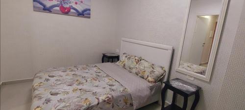 a small bedroom with a bed and a mirror at דירה מול הים בת ים 613 in Bat Yam