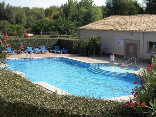 une personne debout dans une piscine dans l'établissement Ombre et soleil vue sur la lagune et bateaux, à Saint-Cyprien