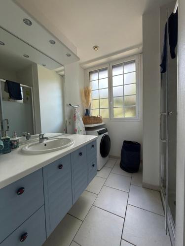 une salle de bain avec un lavabo et une machine à laver dans l'établissement Maison à côté de la Plage Le Moulleau Arcachon, à Arcachon