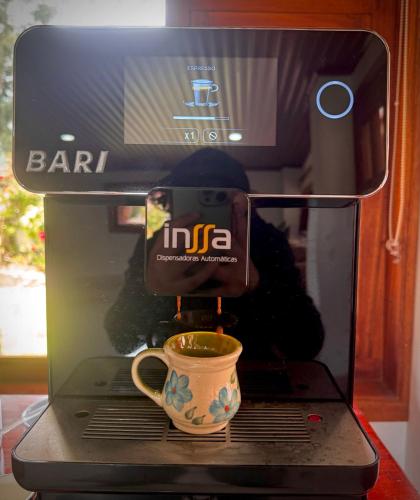 a coffee maker with a cup of coffee in it at Villa Lulu in Tibasosa
