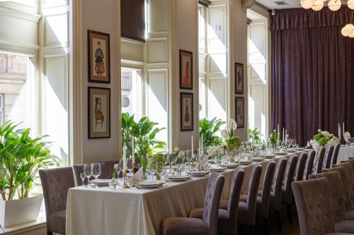 a long dining room with a long table and chairs at Modern Art Hotel in Lviv