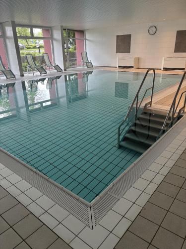 a swimming pool with green tiles on the floor at Ferienwohnungen im Taunusblick in Lahnstein