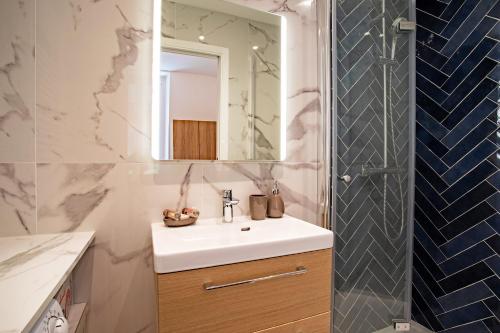 une salle de bain avec un lavabo, un miroir et une douche dans l'établissement ICONIC AP4460 By Riviera Holiday Homes, à Nice