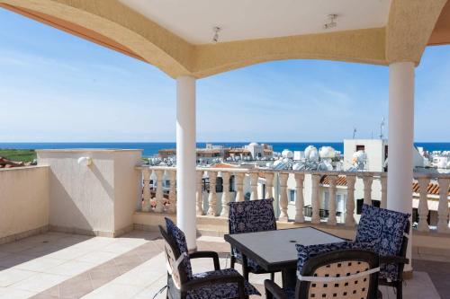a balcony with a table and chairs and the ocean at Penthouse 365 Sunsets in Paphos