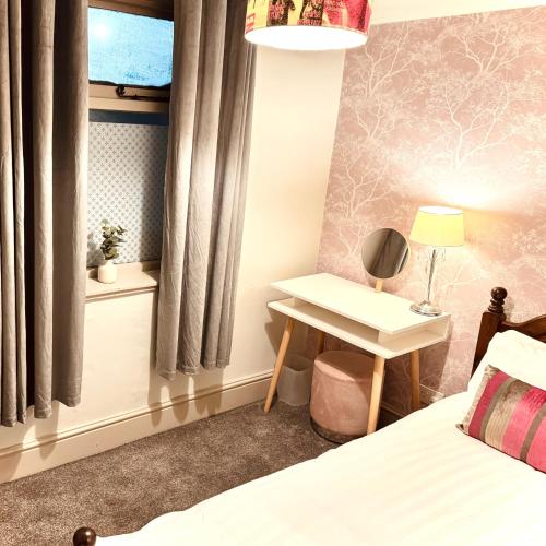 a bedroom with a bed and a table and a window at The Swan Taphouse in Ironbridge