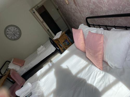 a bedroom with a bed with pillows and a clock at The Swan Taphouse in Ironbridge