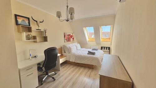 a bedroom with a bed and a desk and a chair at Dandár Family Residence Free Parking in Budapest