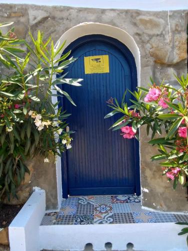 a blue door on a stone building with flowers at Blue ocean villa in Asilah