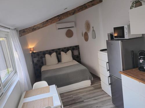 - une petite chambre avec un lit et un réfrigérateur dans l'établissement Studio-Valentine climatisée avec piscine chauffée, à Marseille