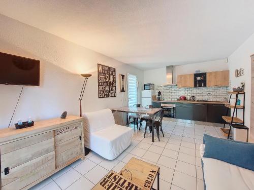 un salon avec une table et une cuisine dans l'établissement S-Pin 01-Soustons Appartement 4 personnes dans résidence avec piscine et tennis, à Soustons