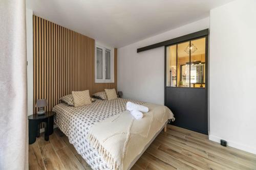 une chambre avec un lit et une grande fenêtre dans l'établissement L'Albert 1er - Appartement design hyper centre - Idéal Curiste, à Vichy