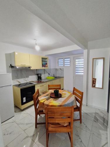 a kitchen with a table and chairs in a room at Chez laRosy in Le Vauclin