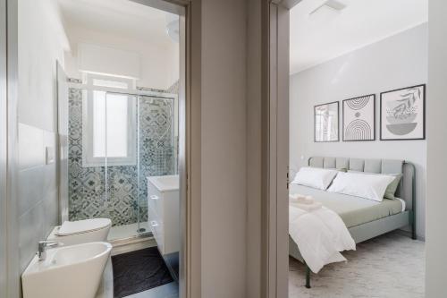 a white bathroom with a bed and a sink at Appartamento Colli in Gallipoli