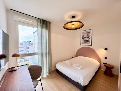 une chambre d'hôtel avec un lit et une fenêtre dans l'établissement We Live Inn Sharies Reims A405, à Reims