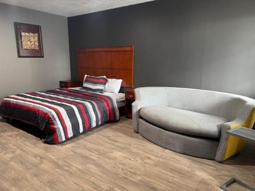 a bedroom with a bed and a chair at Budget Inn New Cumberland-Harrisburg-Hershey-York in New Cumberland