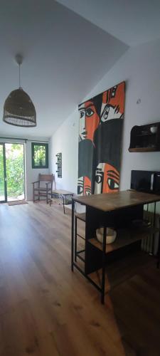Cette chambre dispose d'une table et d'une grande peinture murale. dans l'établissement Studio au cœur de Buis-les-Baronnies, à Buis-les-Baronnies