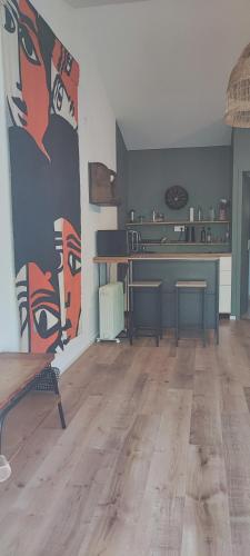 un salon avec un tableau de visages sur le mur dans l'établissement Studio au cœur de Buis-les-Baronnies, à Buis-les-Baronnies