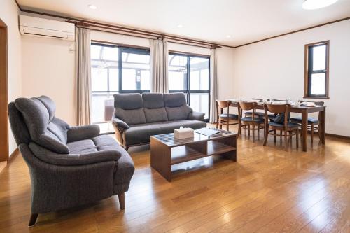 a living room with a couch and a table at Vacation Rental NAGISA in Matsumoto