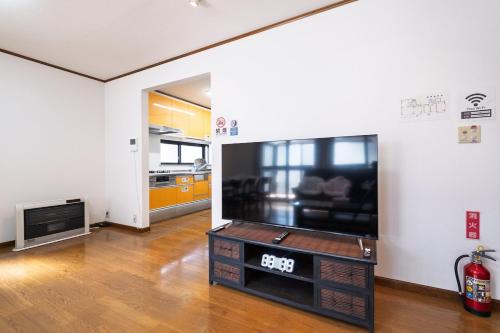a living room with a large flat screen tv at Vacation Rental NAGISA in Matsumoto