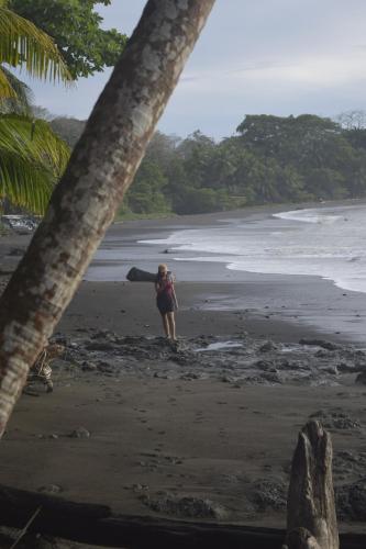 a woman standing on the beach looking at the ocean at Coconut Lodge Pavones in Pavones
