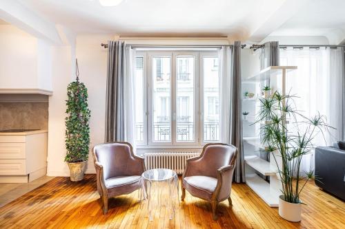 un salon avec deux chaises et une table dans l'établissement GuestReady - Luxury Living in the Heart of Paris, à Paris