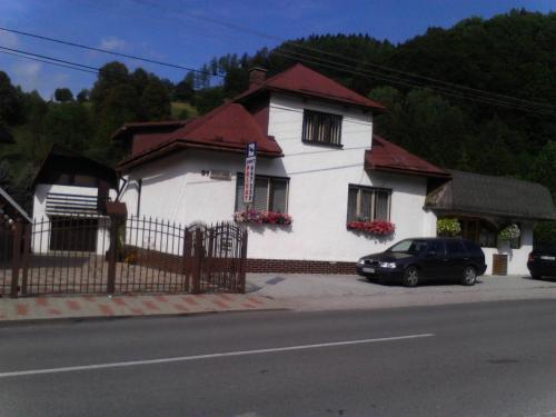 a white house with a car parked in front of it at Rekreačný dom E&Z in Brezno