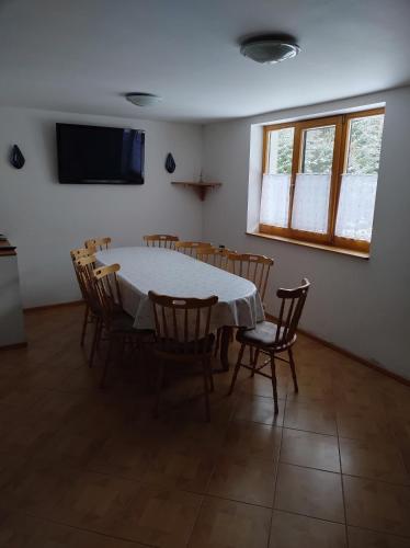 a dining room with a white table and chairs at Rekreačný dom E&Z in Brezno