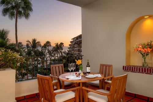 a dining room with a table and chairs and a balcony at Velas Vallarta Suite Resort All-Inclusive in Puerto Vallarta