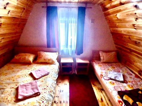 a small room with two beds and a window at Ethno Cottage Momo Tepca in Žabljak