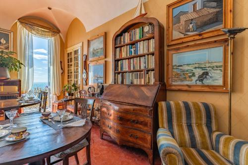 a living room with a table and a book shelf at Casa d'artista - Camere in residenza di Charme in Alassio